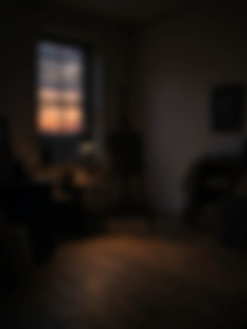 An empty studio at dusk, one lamp and an easel.
