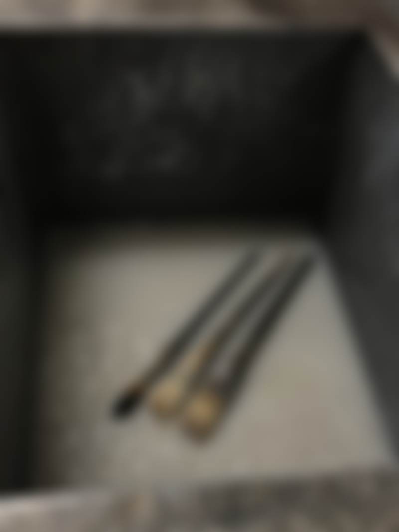 A studio sink with brushes and cloudy water.