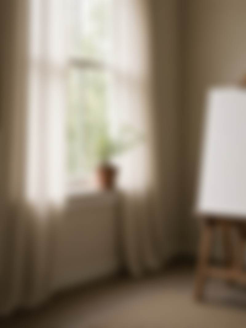 A studio window of north light and the edge of an easel.